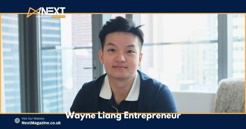 Wayne Liang entrepreneur sitting in modern office with city skyline view wearing navy polo shirt