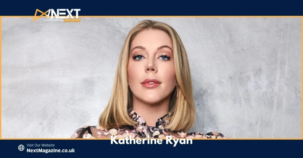 Katherine Ryan blonde comedian posing in floral blouse against grey background for Next Magazine