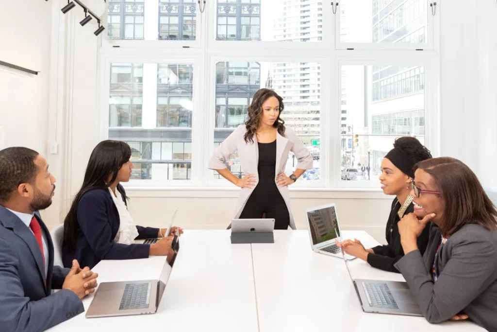 5 Common Challenges and Practical Solutions to Enhance Stakeholder Engagement Efforts - Business - Next Magazine Businesswoman leading a meeting with diverse team members to discuss stakeholder engagement