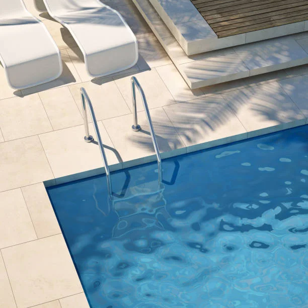 Swimming pool with clear blue water and poolside loungers, indicating well-maintained pool conditions.