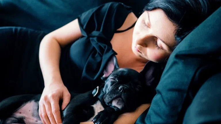 Woman sleeping on a cozy bed with her dog, showcasing a serene and budget-friendly sleep space.