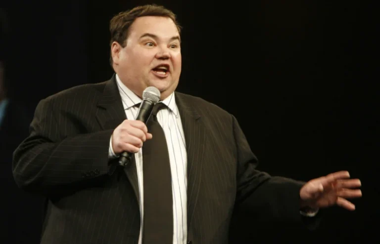 John Pinette performing stand-up comedy, showcasing his signature self-deprecating humor about food and life.