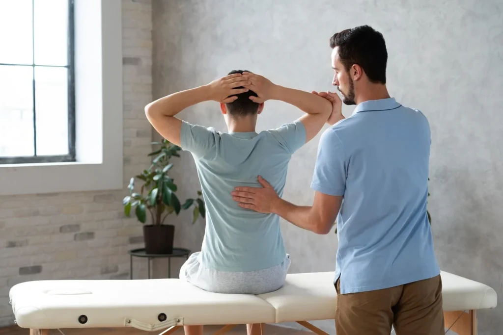 A physiotherapist assisting a patient with back pain through manual therapy in a modern clinic setting.