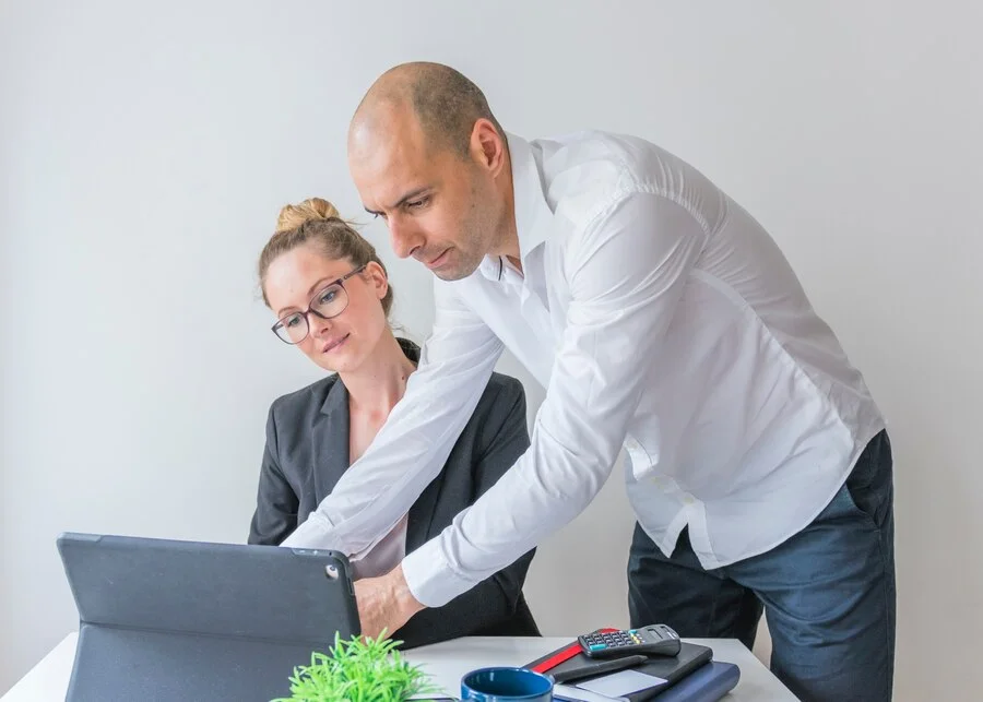 Two professionals reviewing social security disability claim documents on a tablet